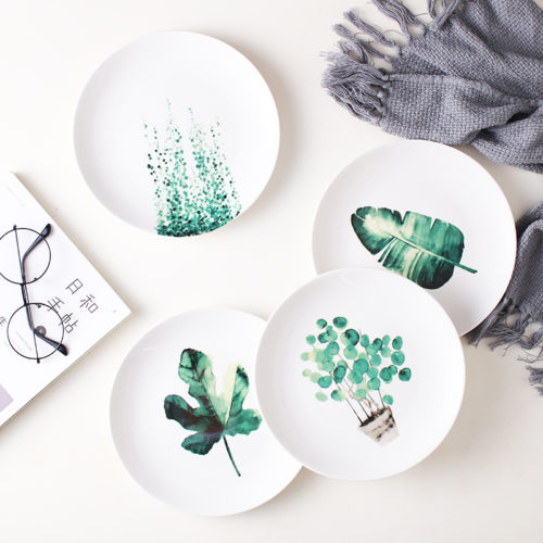 Керамические белые тарелки с зелеными растениями
