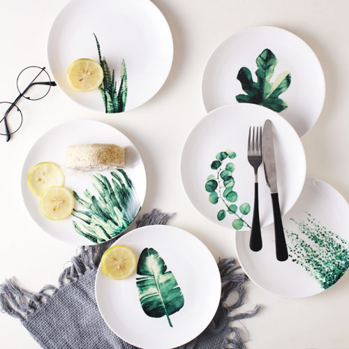 Керамические белые тарелки с зелеными растениями